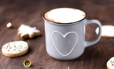 Cozy Cup of cocoa with Christmas gingerbread on a wooden table.