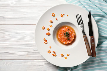 Plate with salmon tartar on white table