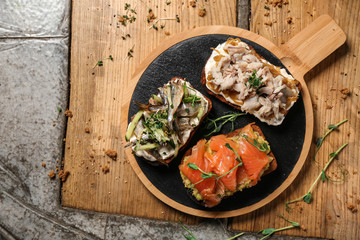 Different open sandwiches with fish on table