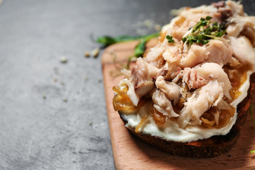 Tasty sandwich with scomber on dark table