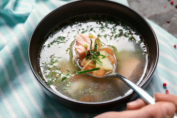 Woman eating tasty fish broth, closeup