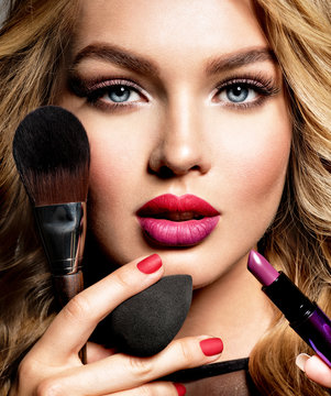 Beautiful Woman Holds Cosmetic Tools. Makeup.