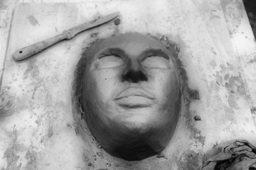 the hands of the sculptor mold the mask