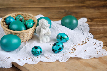 Easter still life. Easter eggs and little angel. Soft focus