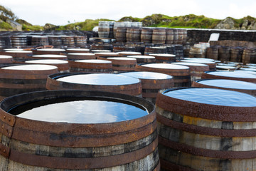 Old wooden barrels and casks with single malt Scotch at whisky distillery in Scotland