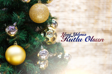Shiny gold and silver christmas balls on white with pine tree. Yeni yılınız kutlu olsun means happy new year