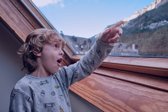 Excited boy looking at mountain through window