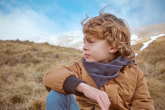 Thoughtful boy sitting on hill