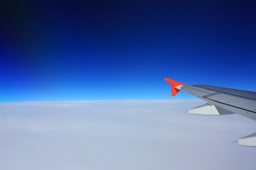 Fototapeta premium Airplane wing in the blue sky