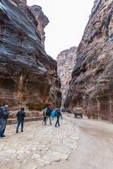 Numerous tourists walk along the canyon leading to Petra - the capital of the Nabatean kingdom in Wadi Musa city in Jordan