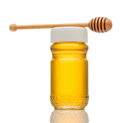 Honey jar with honey dipper on white