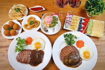 A two man steak dinner with side dishes