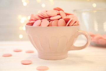 Cup with color chocolate chips on light table