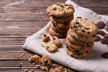 Tasty cookies with chocolate chips on wooden table