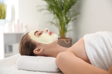 Obraz na płótnie Canvas Young woman with natural facial mask in beauty salon