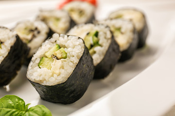 Tasty sushi rolls on plate, closeup