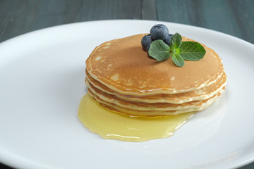 Pancake with blueberries, mint and honey on a white plate. Perfect breakfast