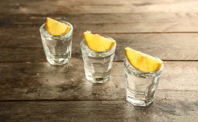 Glasses of vodka on wooden table. Concept of alcoholism