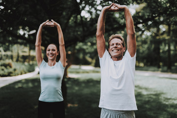 Obraz premium Young Couple in Sportswear Doing Exercises in Park
