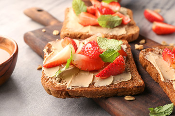 Tasty toasts with strawberry on table, closeup