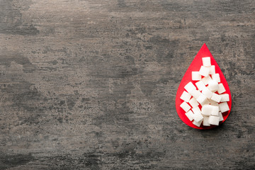Paper blood drop and sugar cubes on wooden table. Diabetes concept