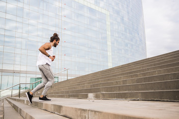 young man with long hair wearing sport wear going up and down  the stairs