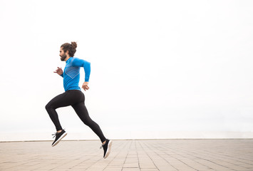 young man with long hair wearing sport wear running