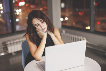 Businesswoman working at the table with a desk lamp.