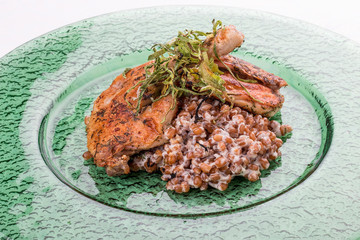 Chicken Tapaka (tabaka, tobacco) with wheat risotto. On white background.