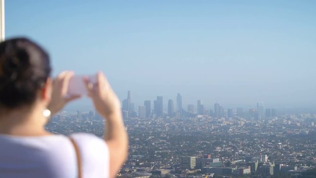 Woman taking picture of downtown in Los Angeles in 4k slow motion 60fps