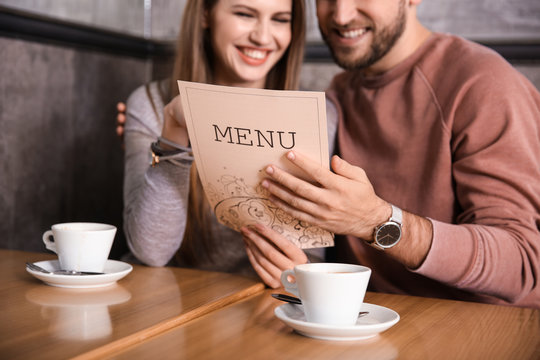 Young couple looking through menu in restaurant