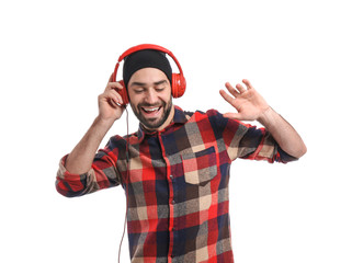 Handsome young man listening to music while dancing on white background