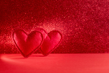 Felt hearts on red background with bokeh. Valentine's day celebration or love concept. Copy space. Toned