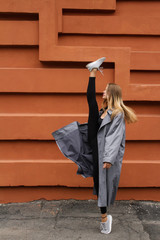 beautiful girl doing gymnastics and performing a twine on the street