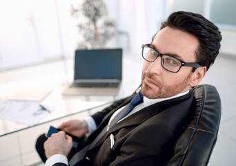 businessman sitting at his Desk and looking at the camera