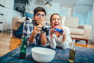 Cute couple playing video games at home