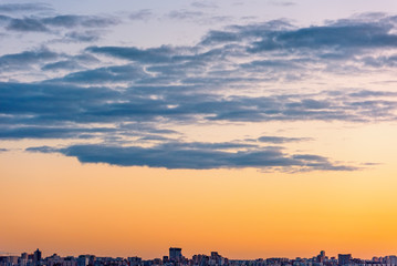 Evening sky over the big city. Sunset and beautiful clouds.