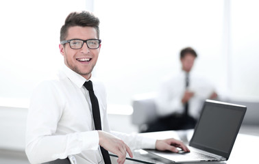 businessman sitting in office with laptop