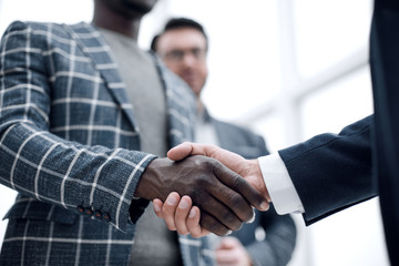 close up.handshake entrepreneurs on the background of the office.