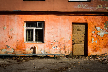 Obraz na płótnie Canvas Old orange wall with a window and door