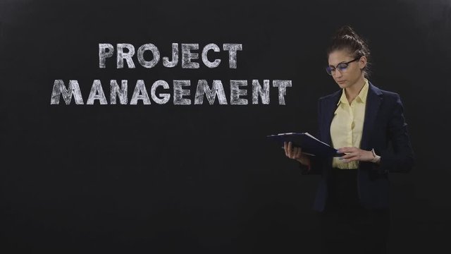 Business lady looking at document and managing project, on black background