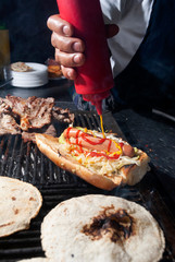 fast street food in the city of guatemala, bread with cabbage sausage, meat, sauces, roasted charcoal called Shuco.