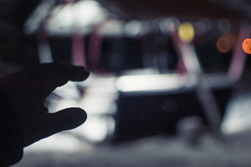 Silhouette of a hand reaching for a shining house at night.