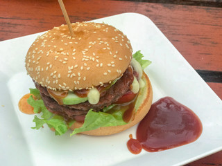 close up of homemade hamburgers with ketchup on white plate