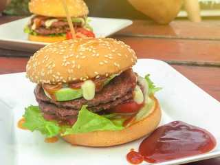 close up of homemade hamburgers with ketchup on white plate