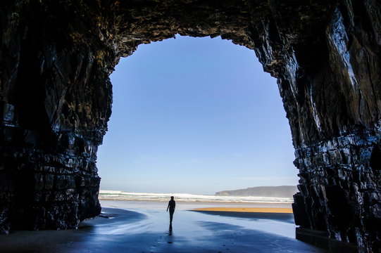 Woman standing in the giant Cathedral caves, The Catlins, South Island, New Zealand