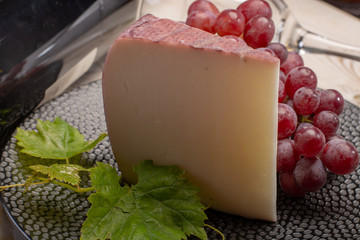 Traditional Spanish cheese, Murcian wine cheese from goat milk with rind washed in red wine, served with fresh ripe grapes