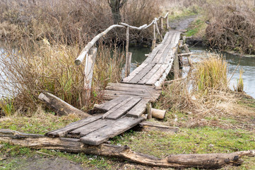 Wooden bridge over a small river in the village in autumn. Background