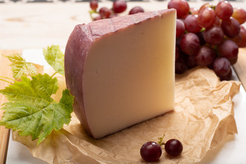 Traditional Spanish cheese, Murcian wine cheese from goat milk with rind washed in red wine, served with fresh ripe grapes