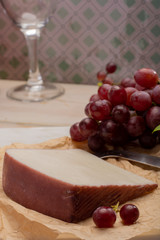 Traditional Spanish cheese, Murcian wine cheese from goat milk with rind washed in red wine, served with fresh ripe grapes